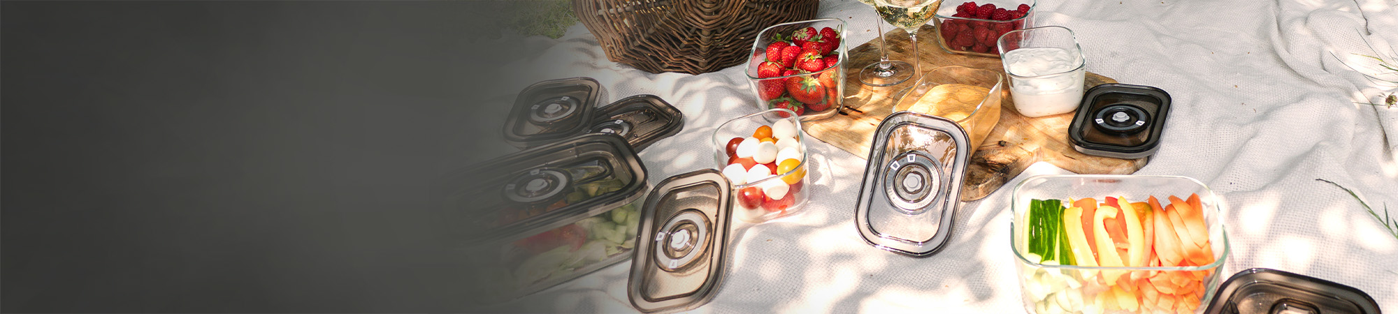Picnic with glass containers full of food and drinks on a blanket outdoors