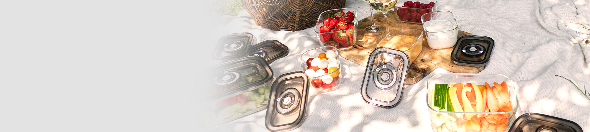 Picnic with glass containers full of food and drinks on a blanket outdoors