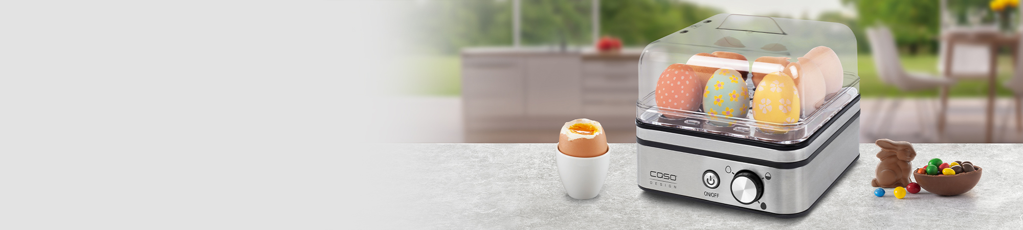 Osterdekoration mit Eierkocher, Schokoladenhase und Ostereiern