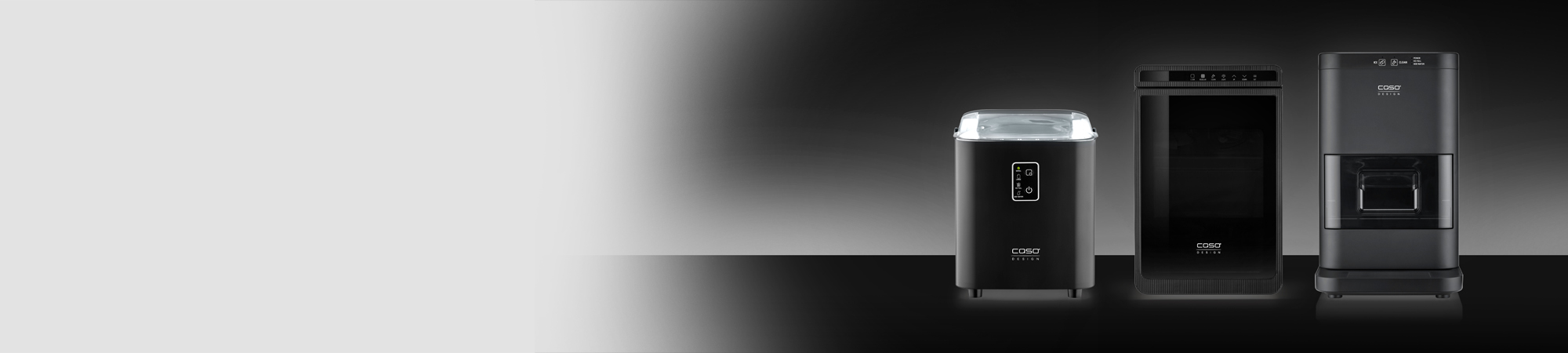 Vier schwarze Haushaltsgeräte von Caso Design stehen nebeneinander auf einer glänzenden Oberfläche vor einem grauen Hintergrund.