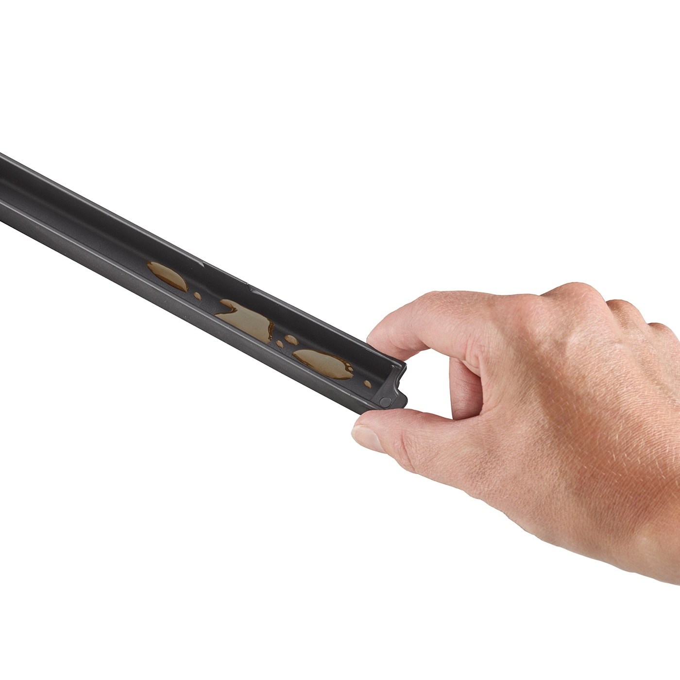 Hand holding black object with liquid, close-up, isolated on white