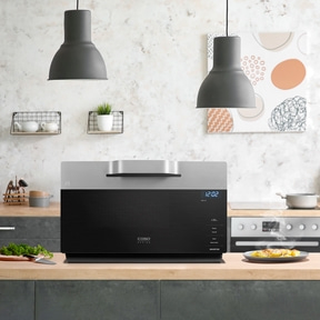 Modern microwave in kitchen with food and decorative elements