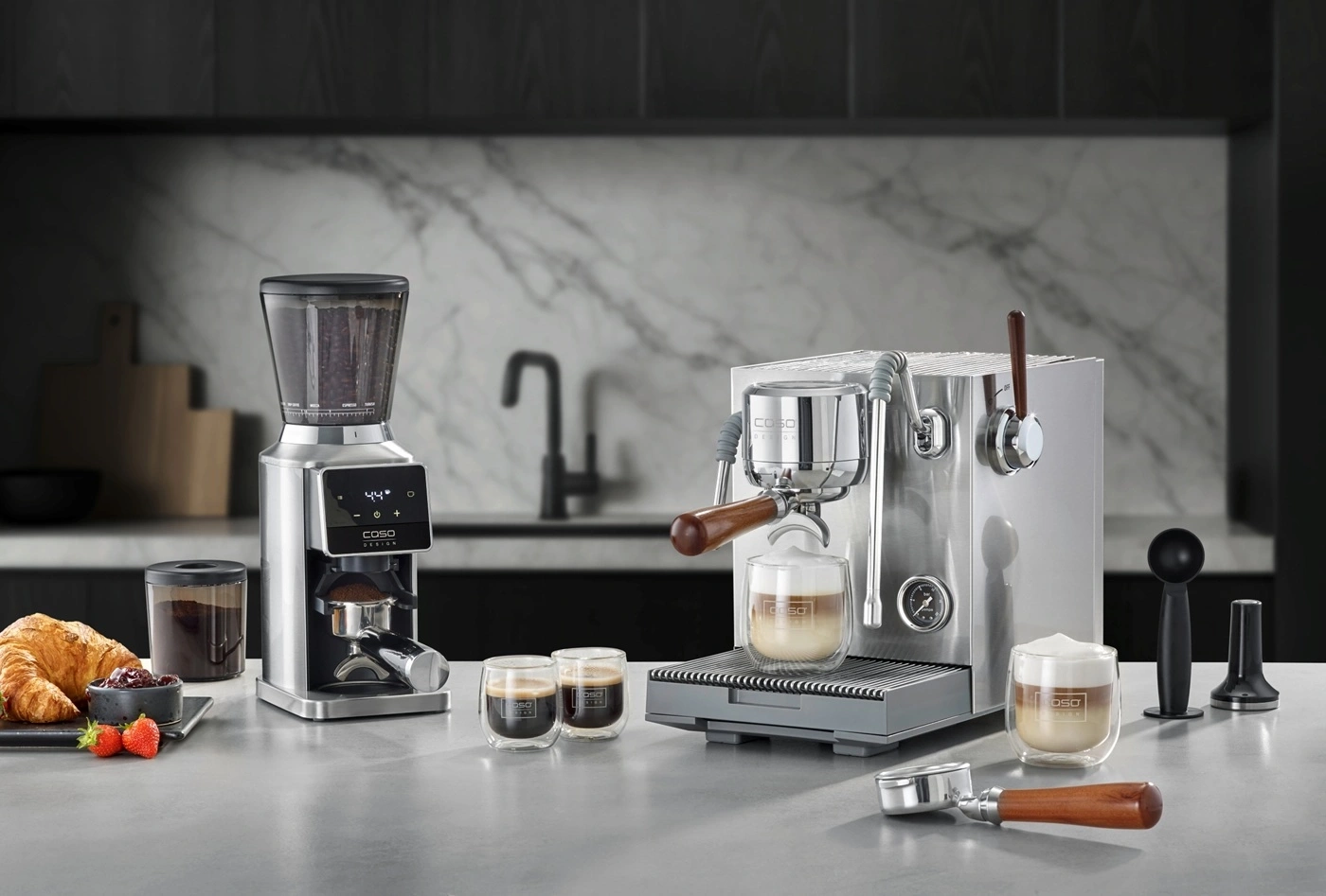 Kaffeemaschine und Kaffeemühle mit Frühstück auf der Arbeitsplatte