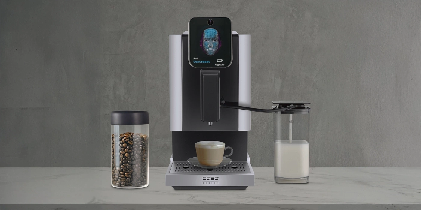 Kaffeemaschine mit Gesichtserkennung, Kaffeebohnen und Milchbehälter auf Marmortisch