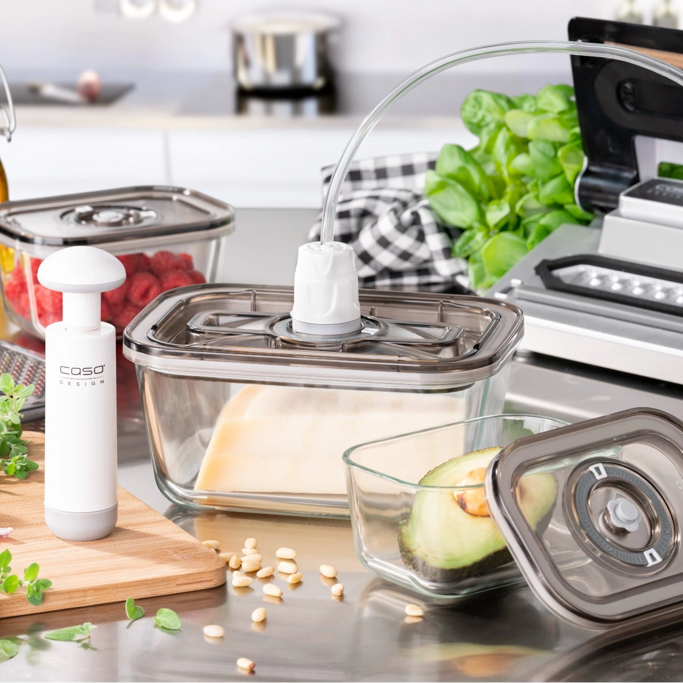 Vacuum containers with food, pump, and vacuum sealer on a kitchen countertop