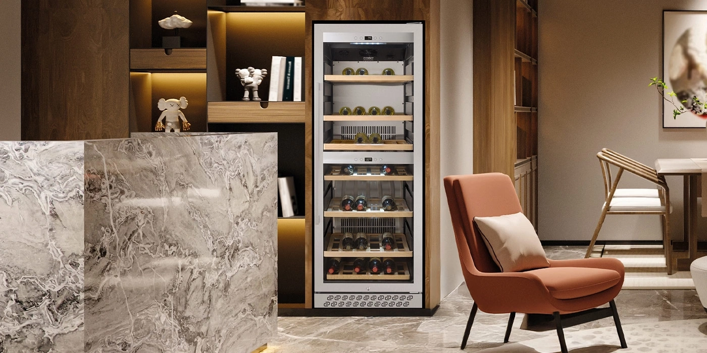 A modern living space featuring a wine fridge, armchair, and marble counter.