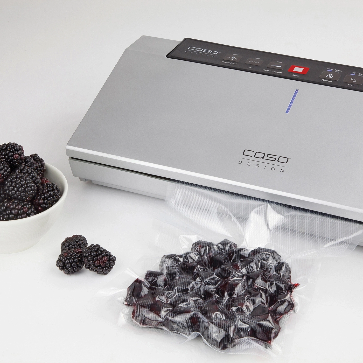 Blackberries are being vacuum-packed to preserve their freshness with a vacuum sealer.