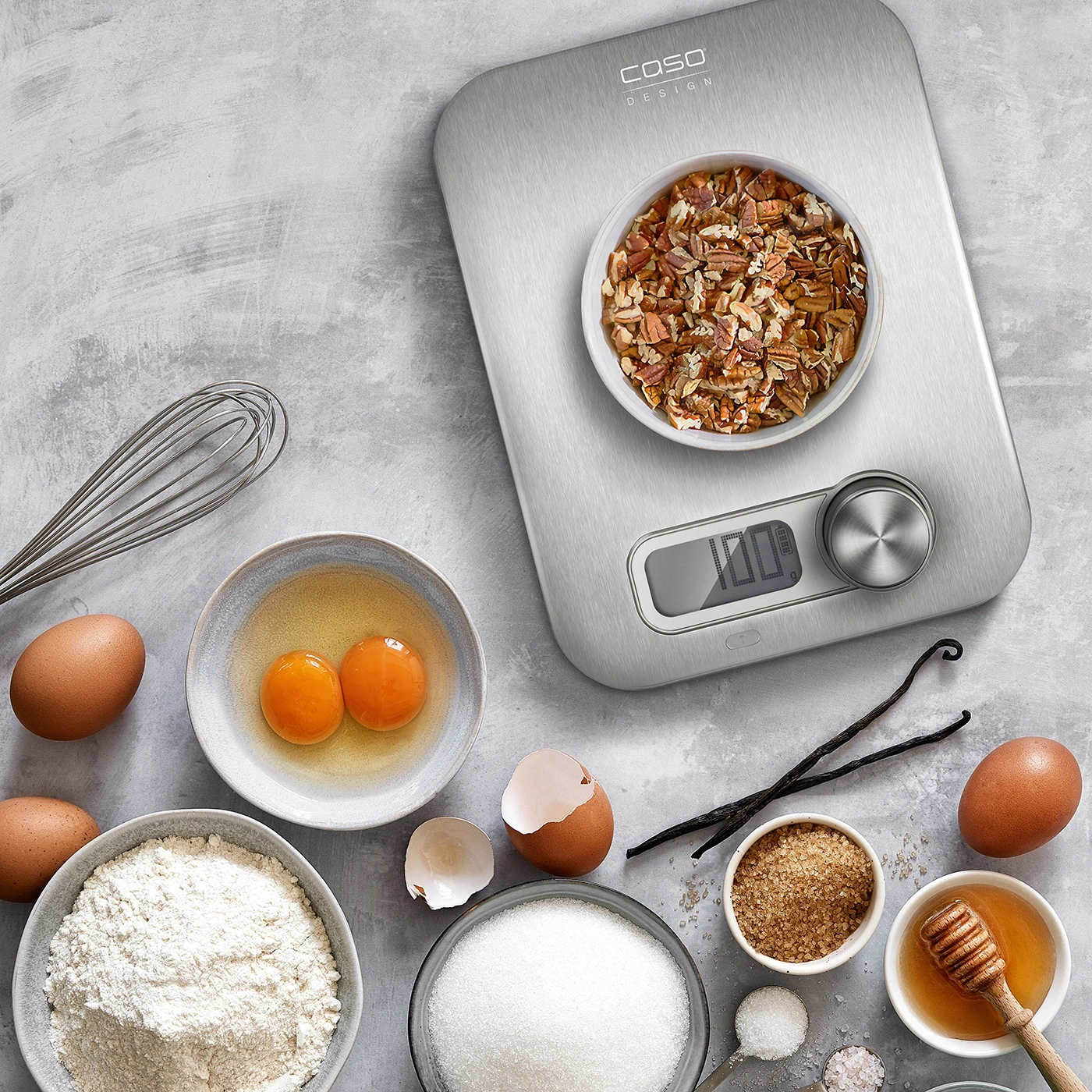 Baking ingredients on a scale, eggs, flour, sugar, honey, vanilla beans, nuts