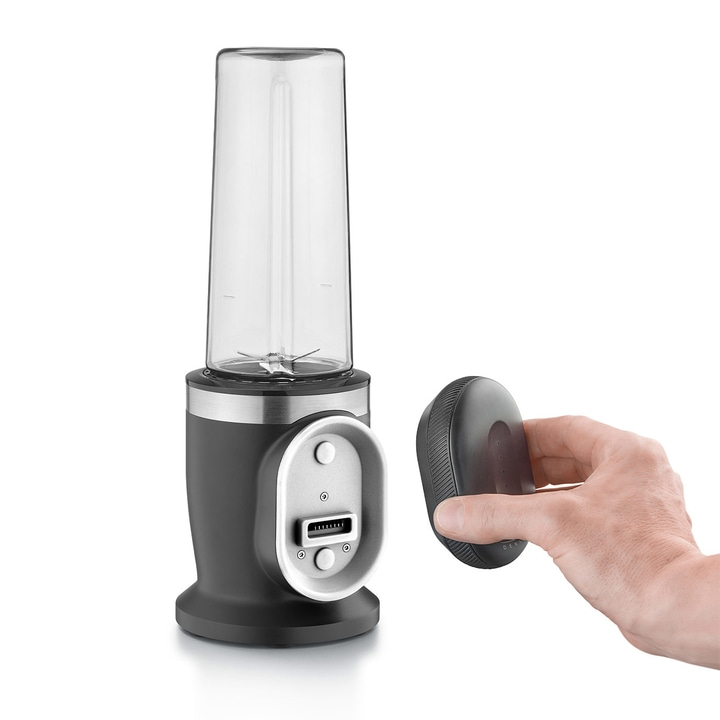 Black blender with removable container and control panel held by a hand, isolated.