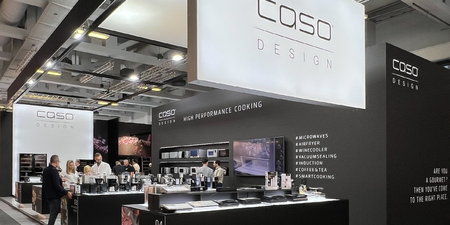 CASO Design booth with water heater, sous vide machine, and fair visitors.