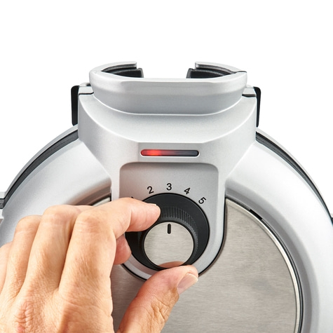 Hand turning the knob of a device set to 1, with numbers 2, 3, 4, 5.