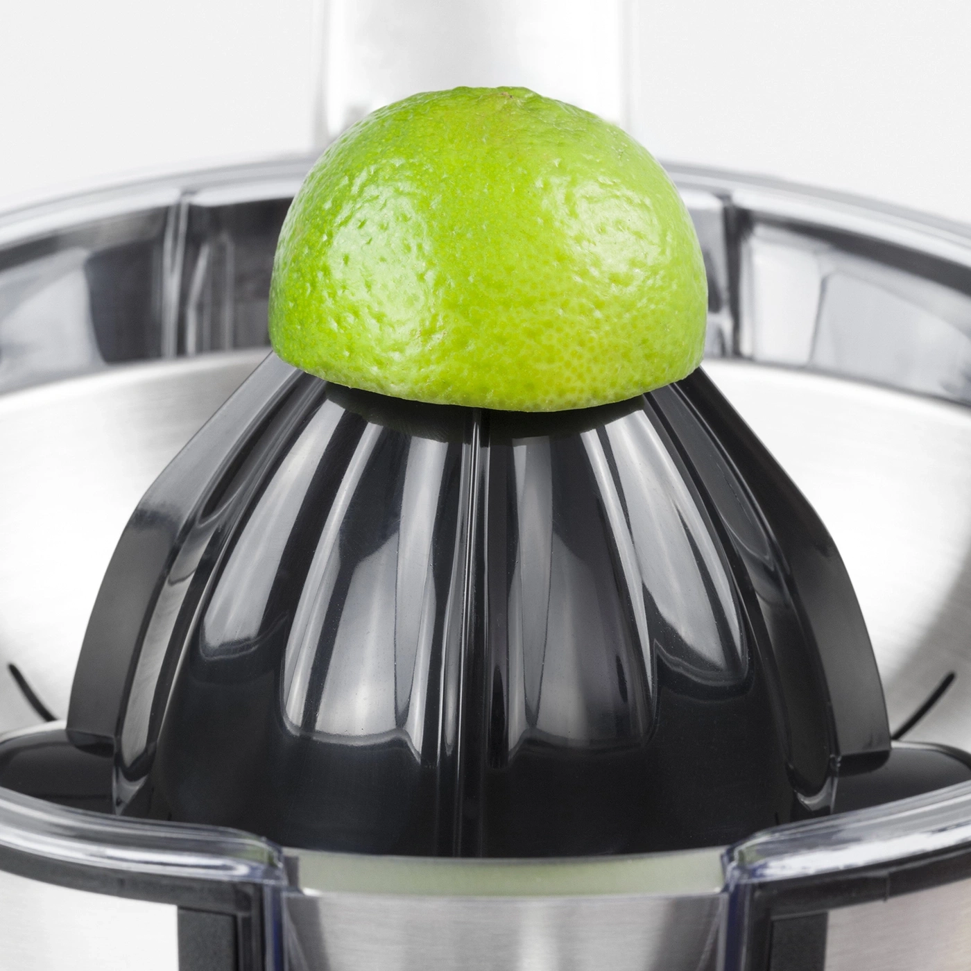 A lime on a black juicer. Close-up shot. Citrus press. Kitchen appliance.