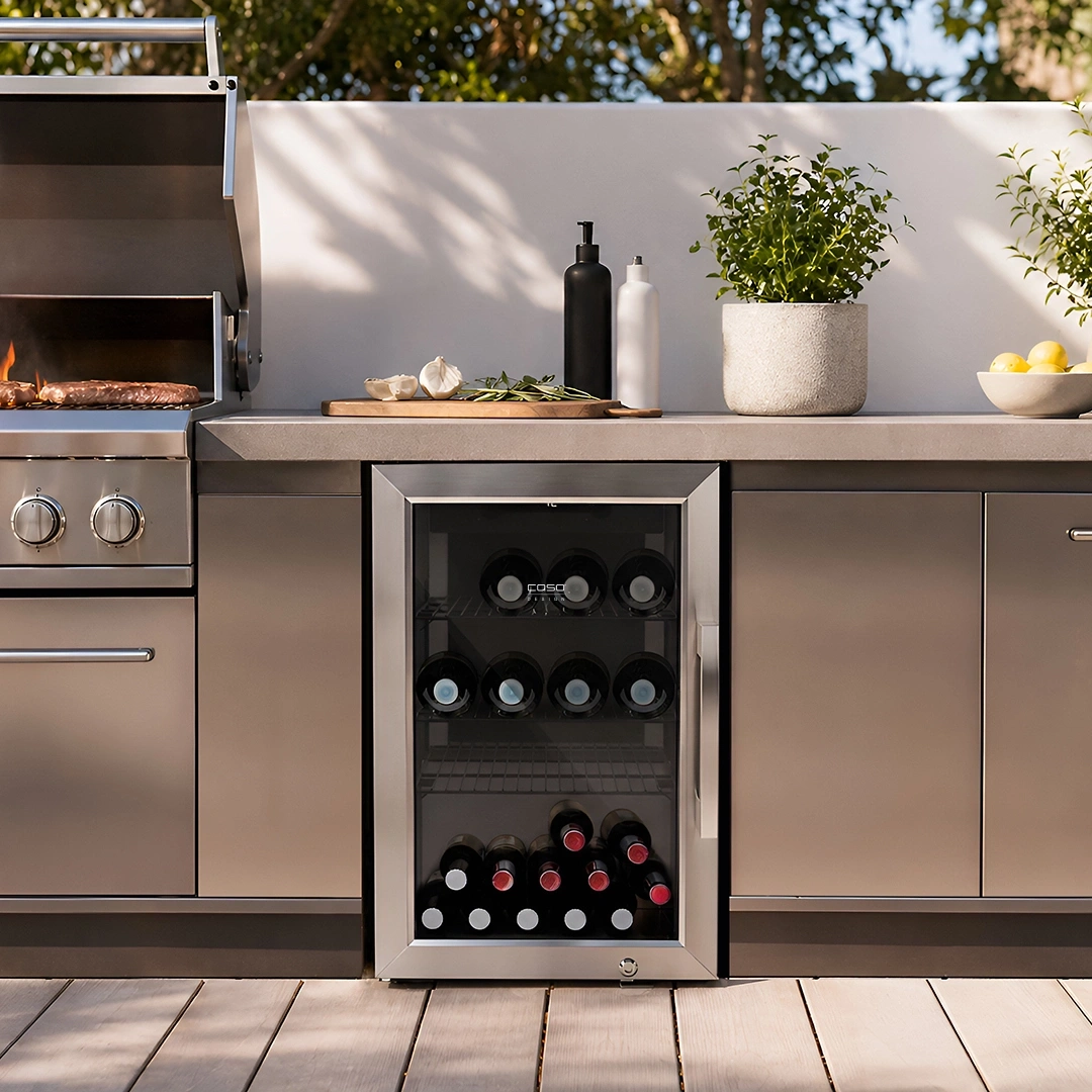 A modern outdoor kitchen area featuring a grill, wine cooler, bottles, and lemons.