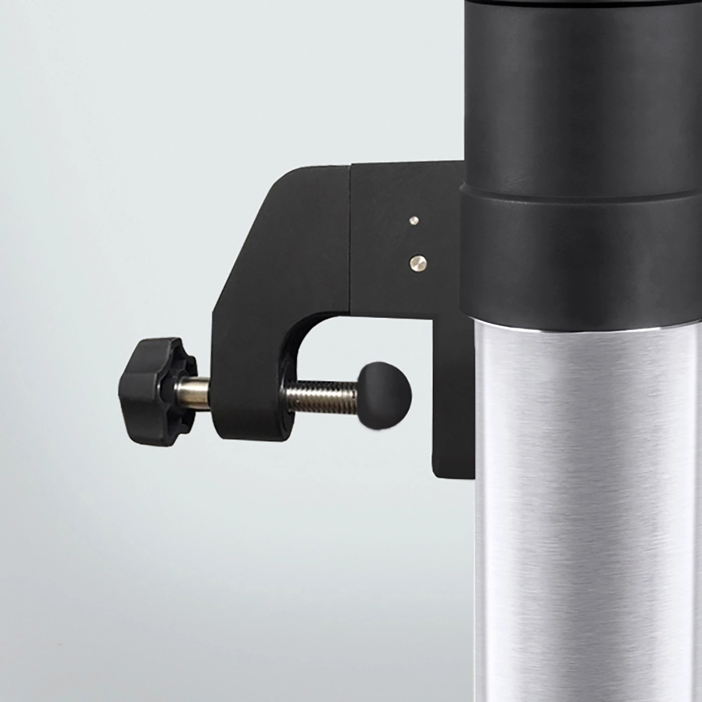 Black clamp on a silver cylinder with a black knob, close-up shot.