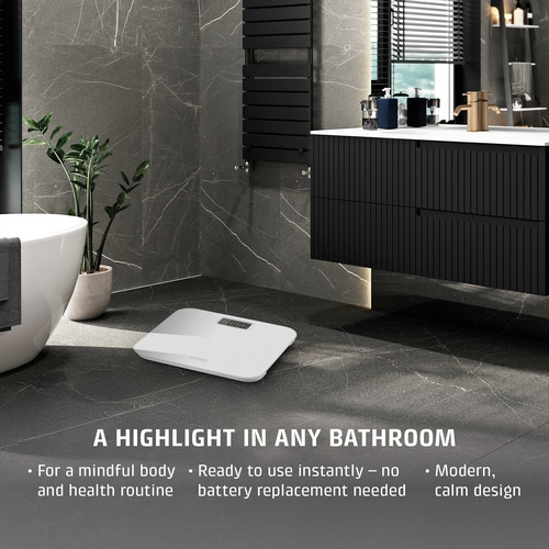 A white bathroom scale in a modern bathroom setting.