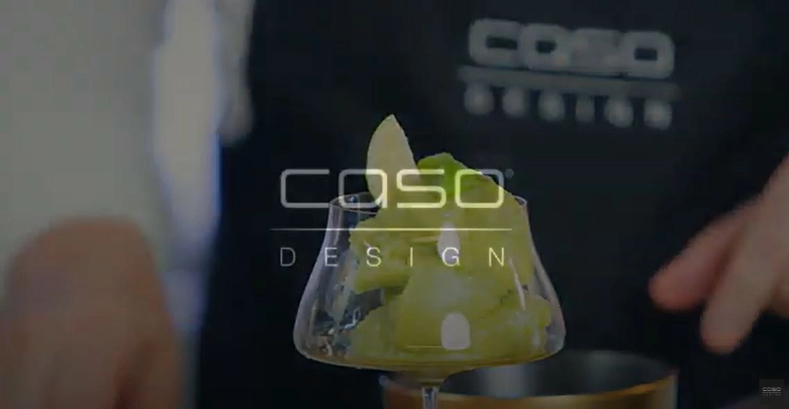 Glass with green drink, CASO Design logo, apple slice, cocktail, kitchen