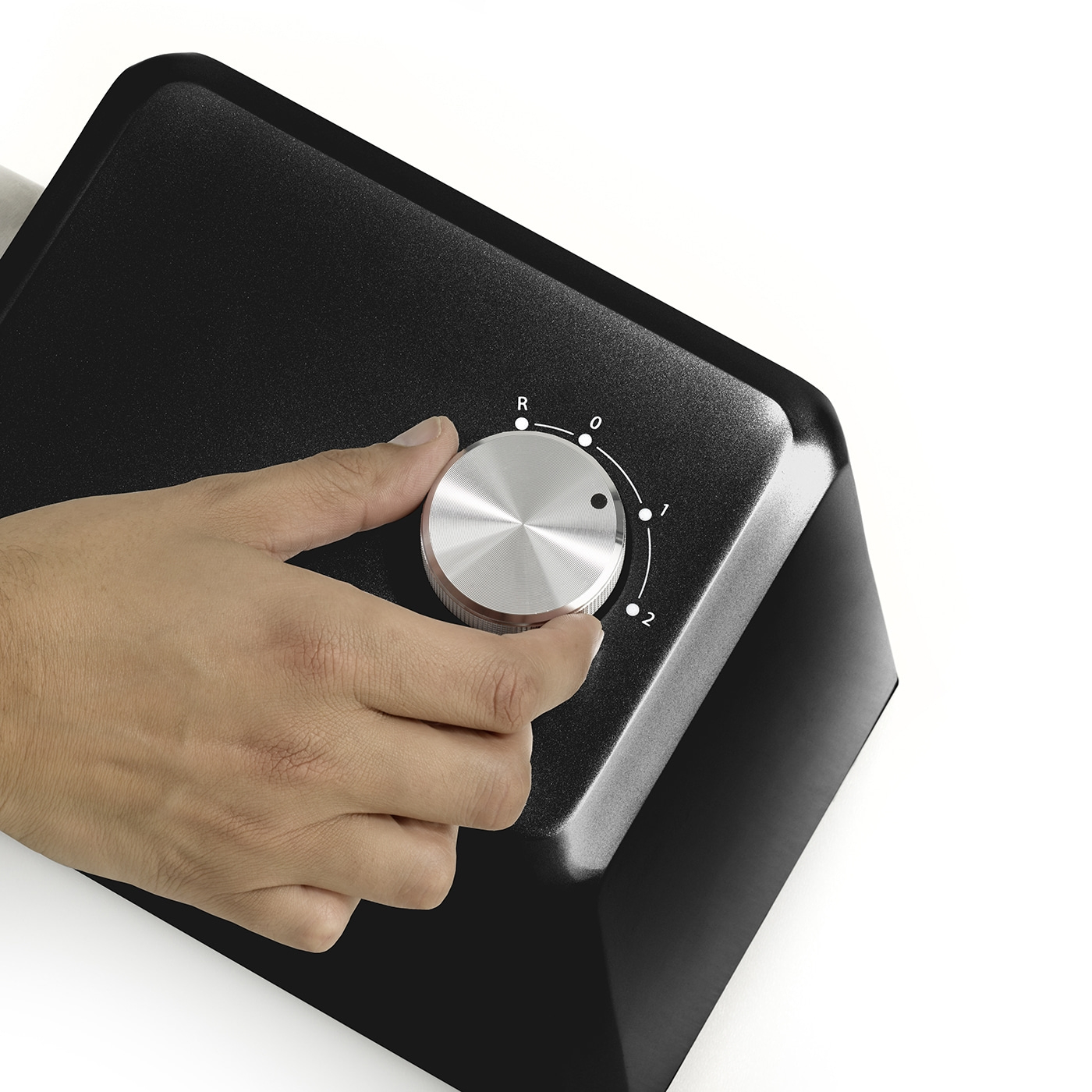 Hand turning knob on black device, settings from R to 2