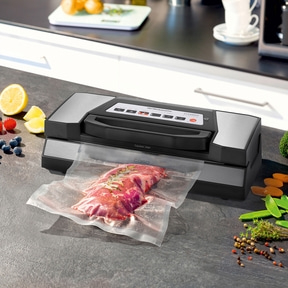 Vacuum sealer with meat, lemon, and vegetables on a countertop