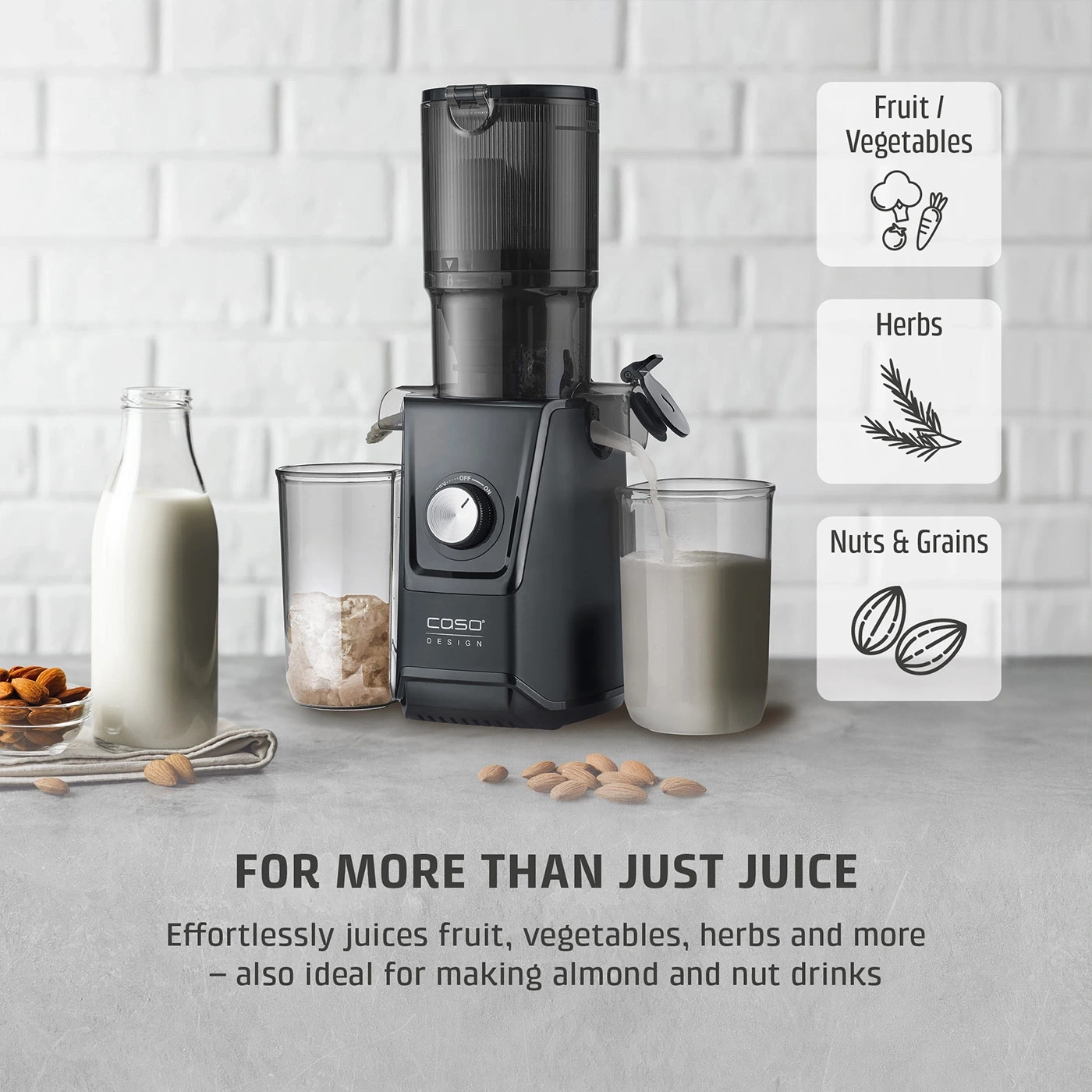 A black juicer with fruits, vegetables, herbs, and nuts.