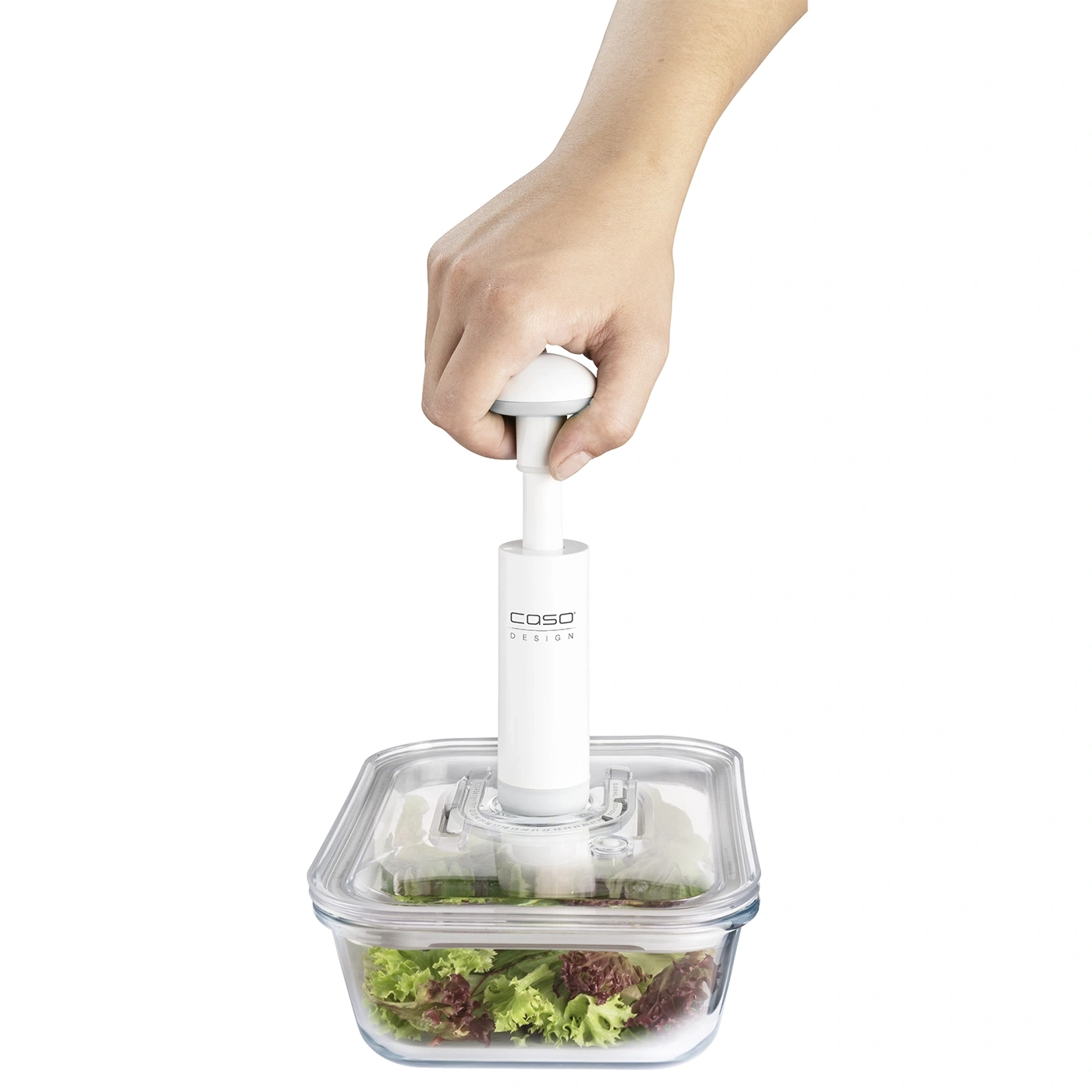 Person vacuuming salad in glass container with pump. Fresh food preservation.