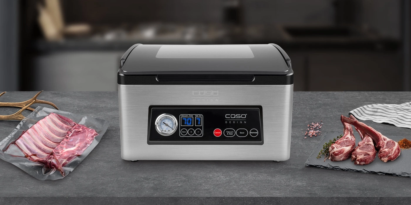 Vacuum sealer with meat and ingredients on a dark surface, ready to use.
