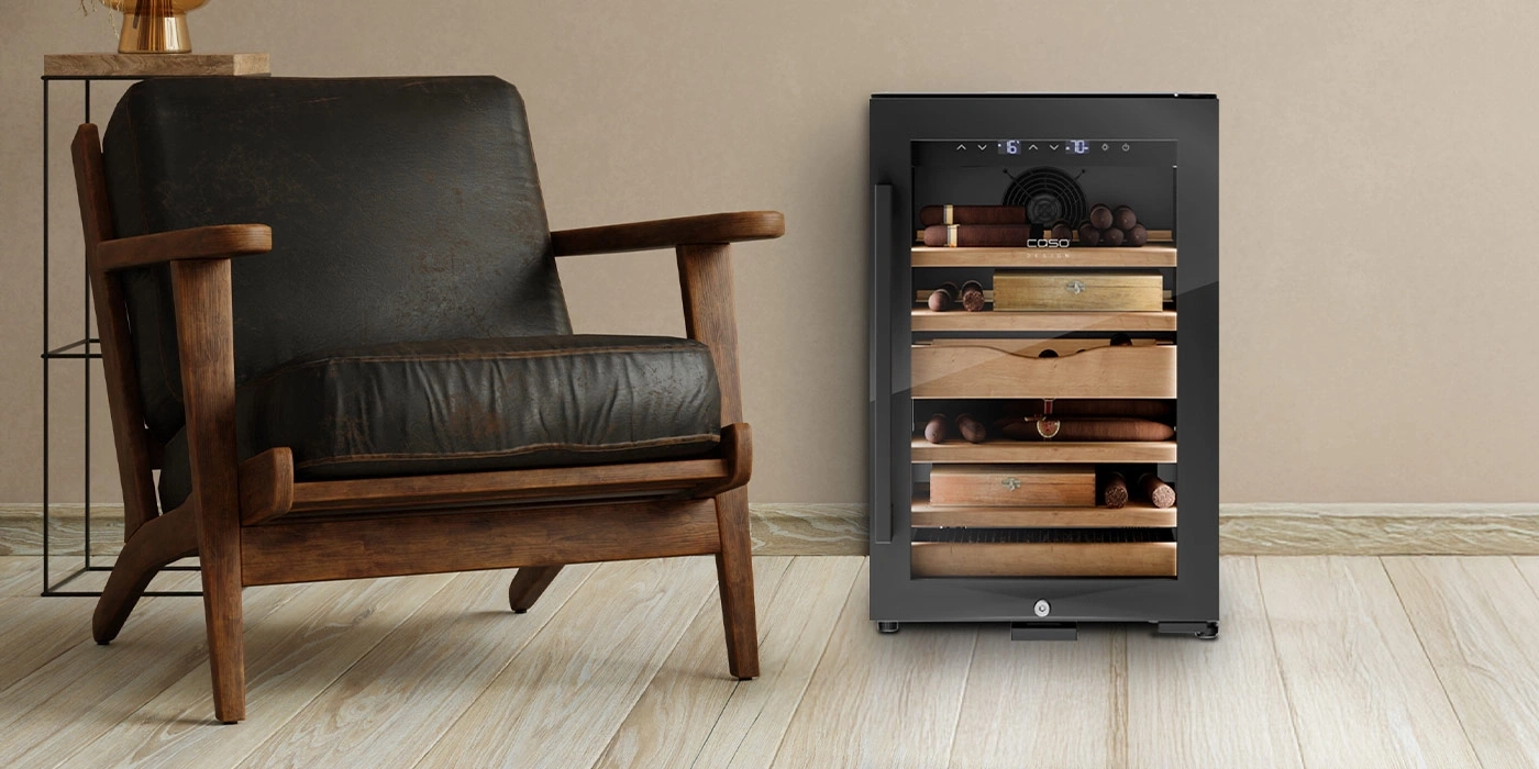 Ein Ledersessel neben einem Zigarrenkühlschrank auf Holzboden.