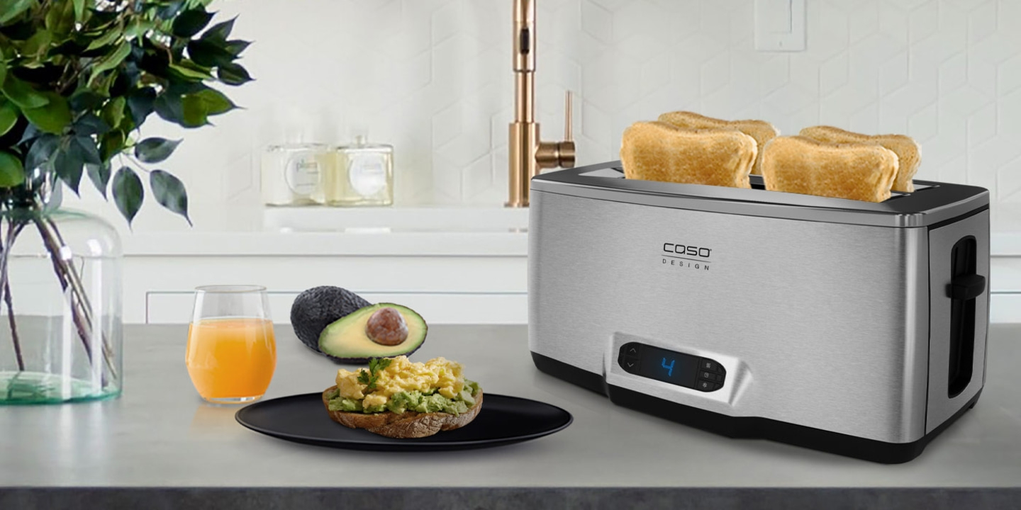 Frühstück mit Toast, Avocado und Saft neben einem Toaster in der Küche