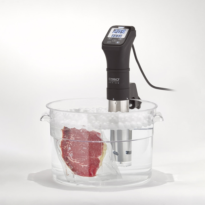 Sous-Vide-Gerät mit Fleisch in einem Wasserbad. Temperaturanzeige und Zeit.