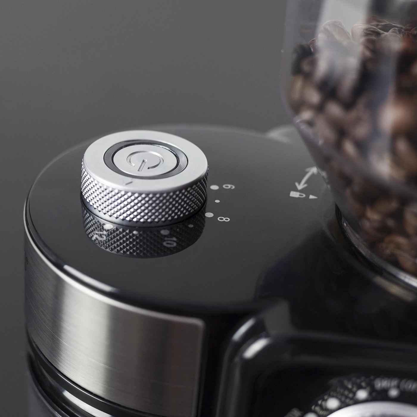 Close-up of a coffee grinder with power button and coffee bean container.