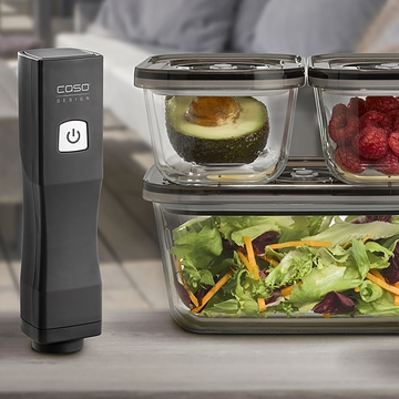 Vacuum sealer with containers, avocado, raspberries, and salad.