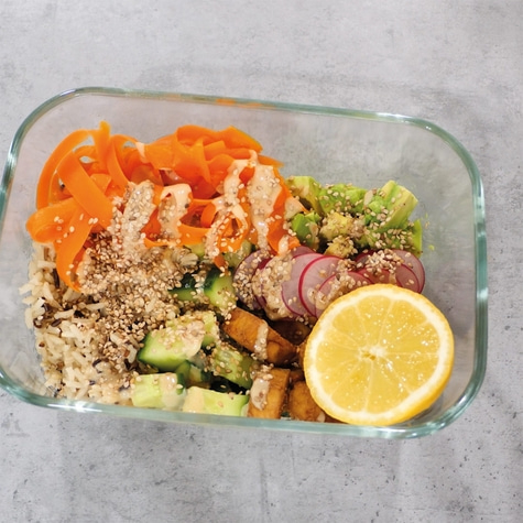 Healthy bowl with vegetables, rice, tofu, and lemon. Delicious and balanced meal.