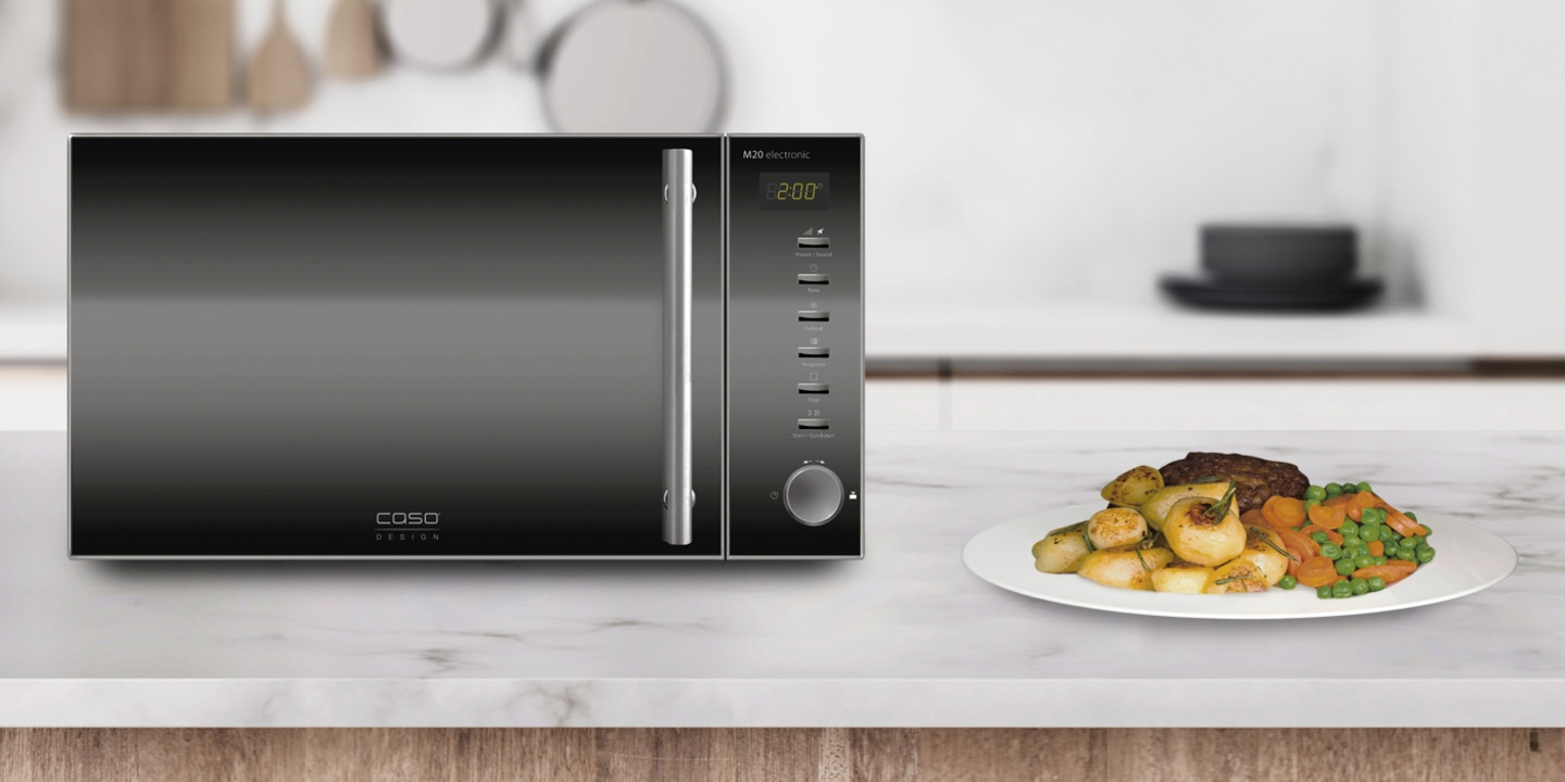 Microwave with food on a plate on a marble surface in a kitchen