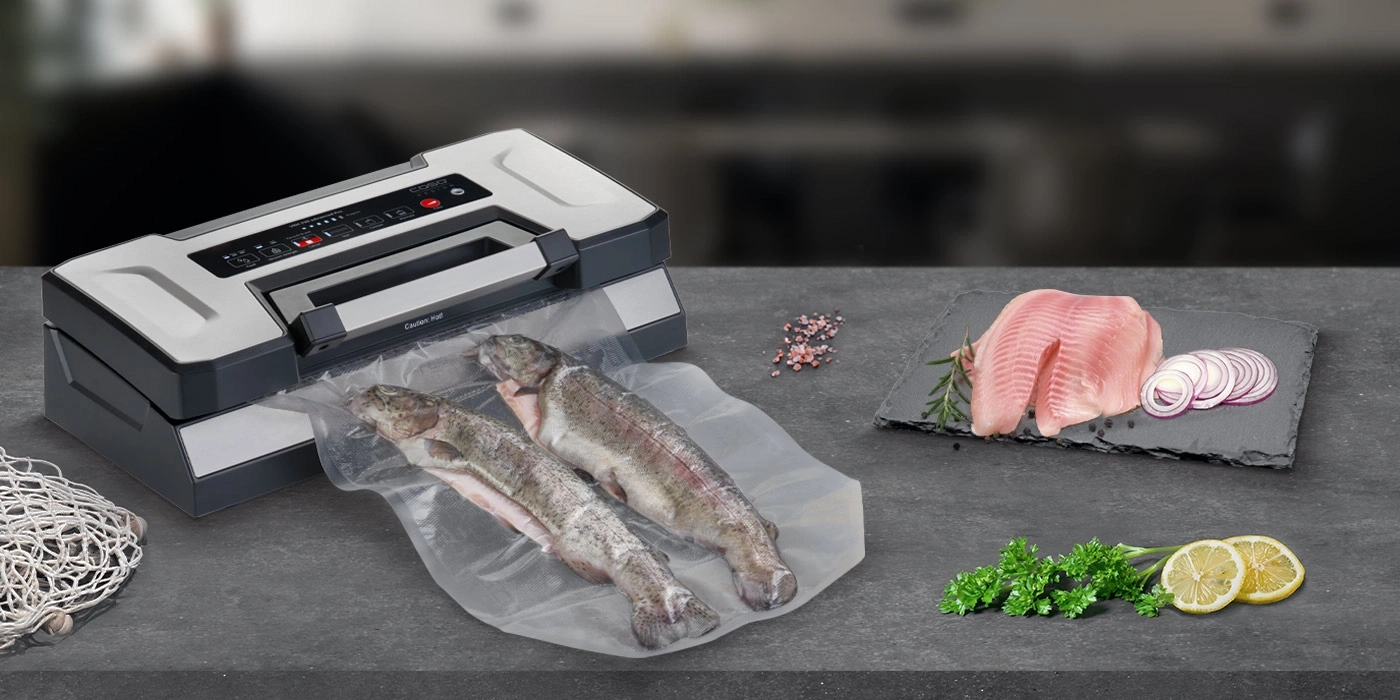 Vacuum sealer with fish and ingredients on a dark surface