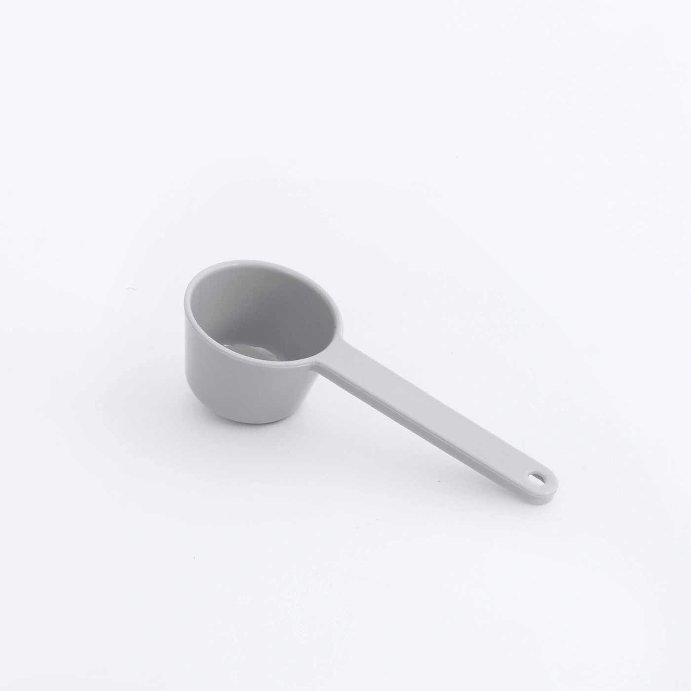 Gray measuring spoon on white background, isolated, close-up, kitchen utensil