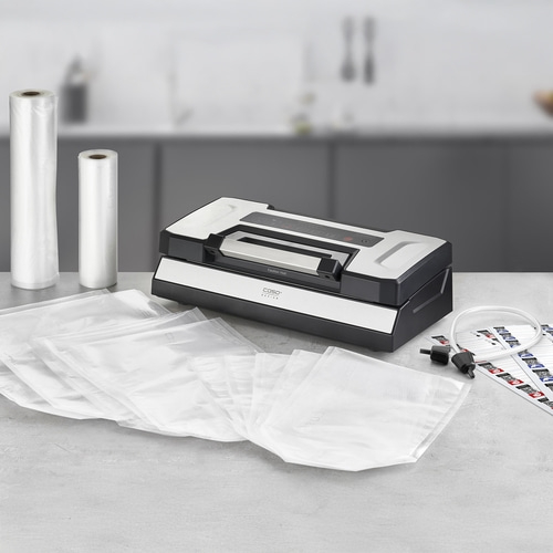 Vacuum sealer with accessories and bags on a gray surface.