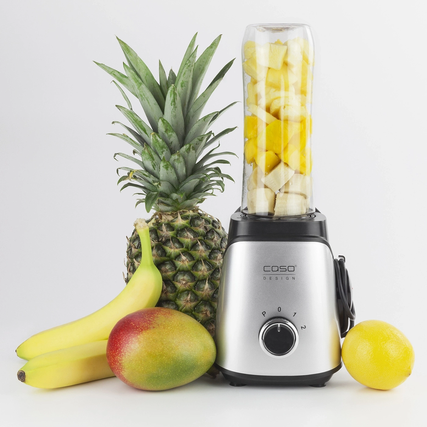 Pineapple, bananas, mango, lemon and blender for a smoothie on a white background.