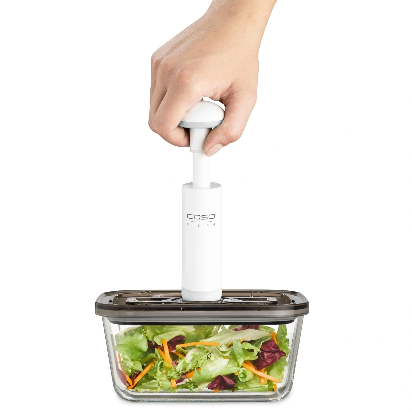 Hand holding vacuum pump over salad in glass container, Caso Design