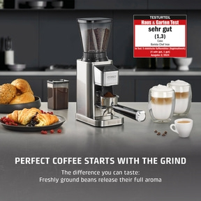 Coffee grinder with coffee and pastries on a countertop