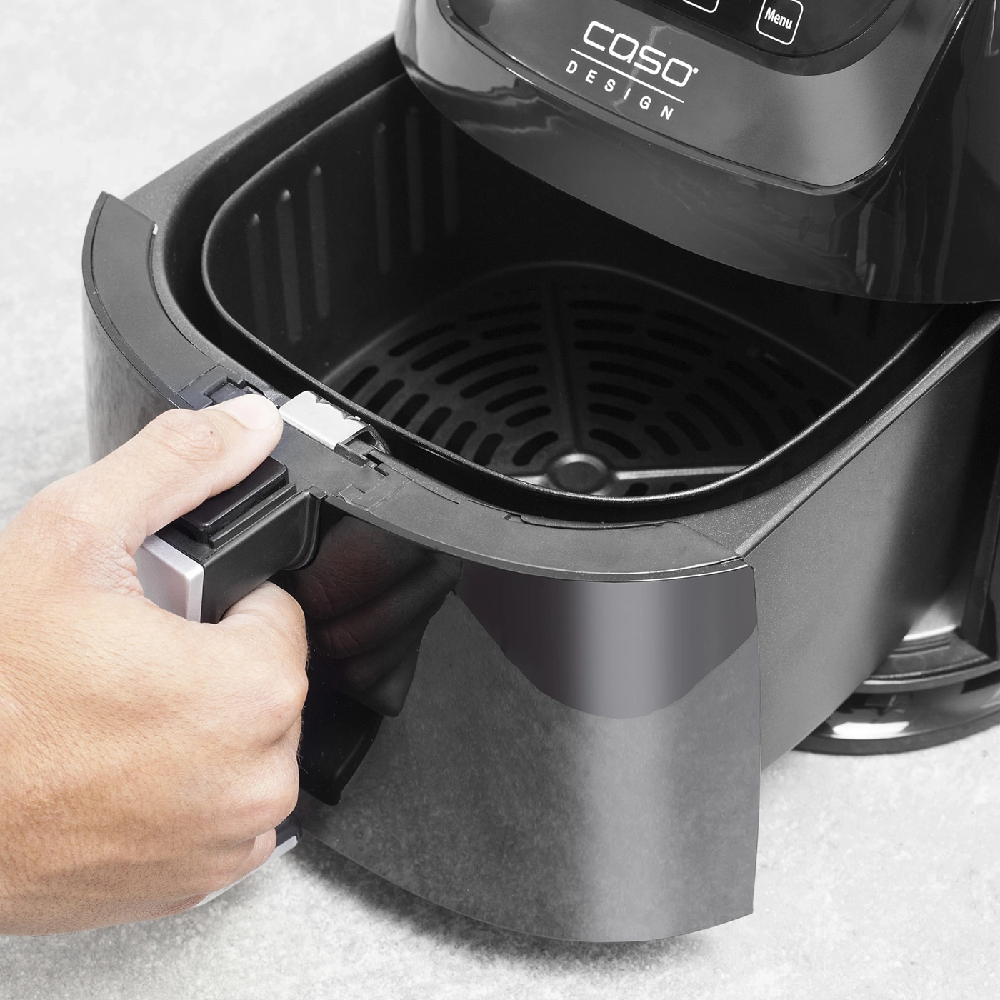 Close-up of a black air fryer with handle and control panel