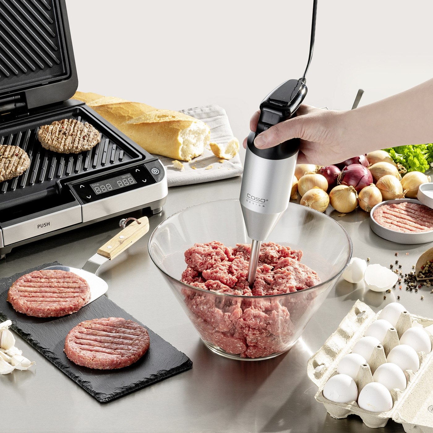 Burger zubereiten mit Grill, Hackfleisch, Eiern und Zwiebeln. Kochen in der Küche.
