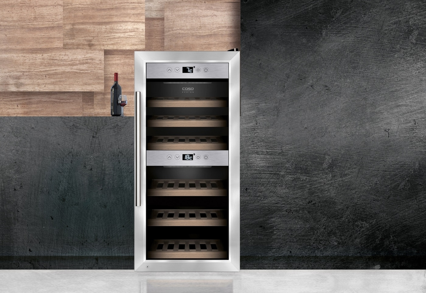 Weinkühlschrank mit Flasche und Glas auf einer Theke vor einer Wand.