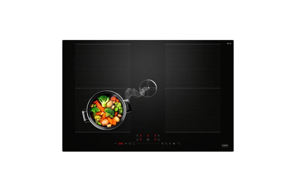A modern black induction cooktop with pots and vegetables.