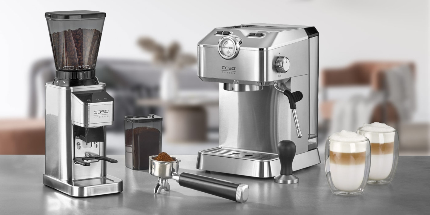 Coffee machine, coffee grinder, and latte macchiato glasses on a countertop.