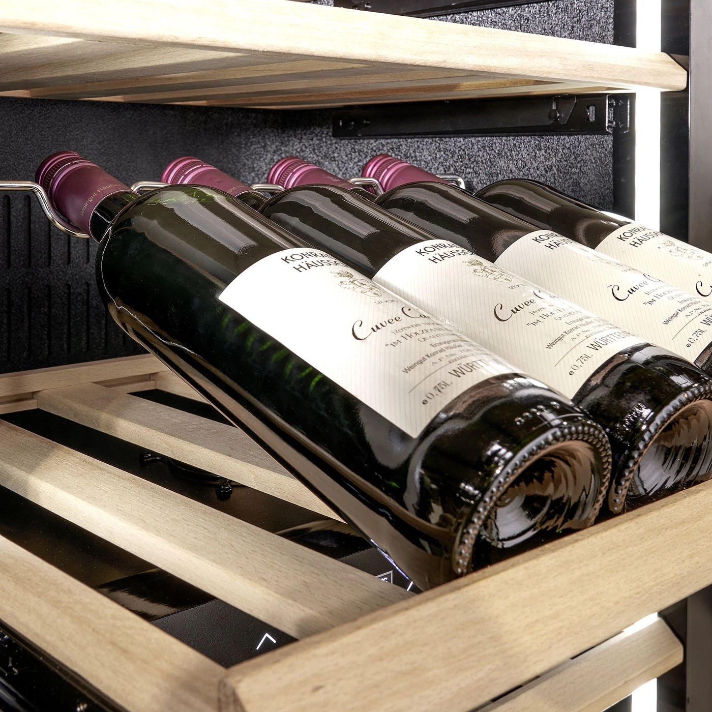 Wine bottles in a wine cooler, wooden shelves, labels, close-up, wine storage, detail