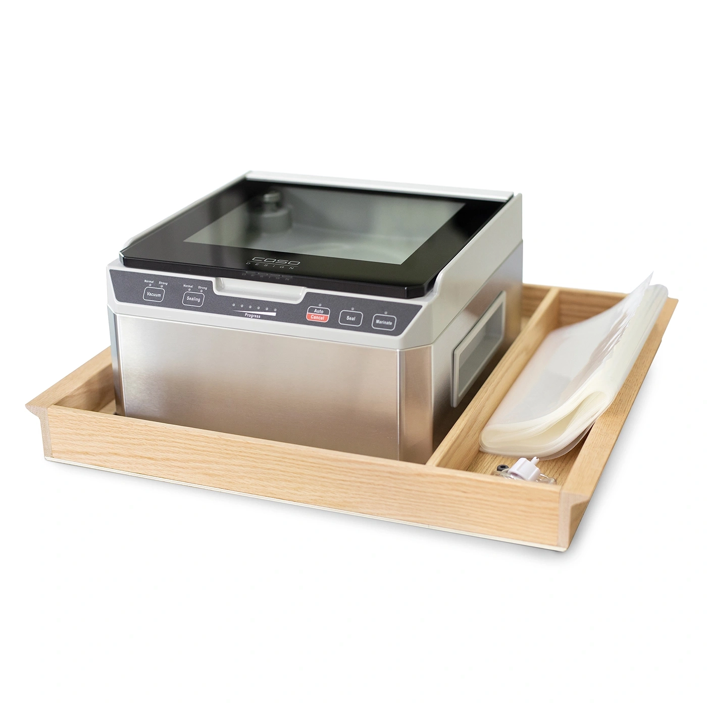 Vacuum sealer with accessories in a wooden tray, white background