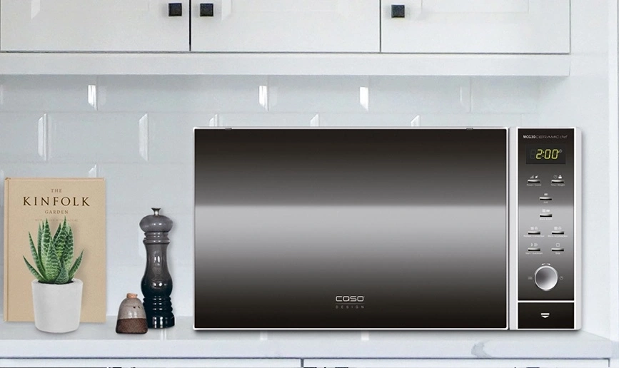 Microwave with accessories on a kitchen shelf, modern and stylish design.
