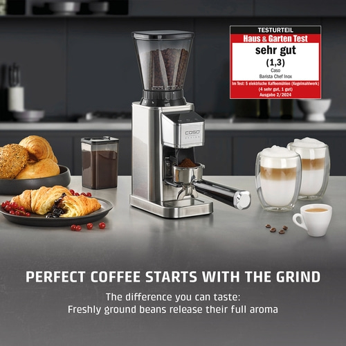 Coffee grinder with coffee and pastries on a countertop