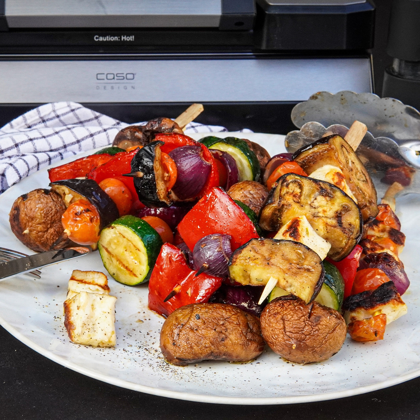 Gebratenes Steak mit Tomaten, Brot und Bier neben Vakuumiergerät.