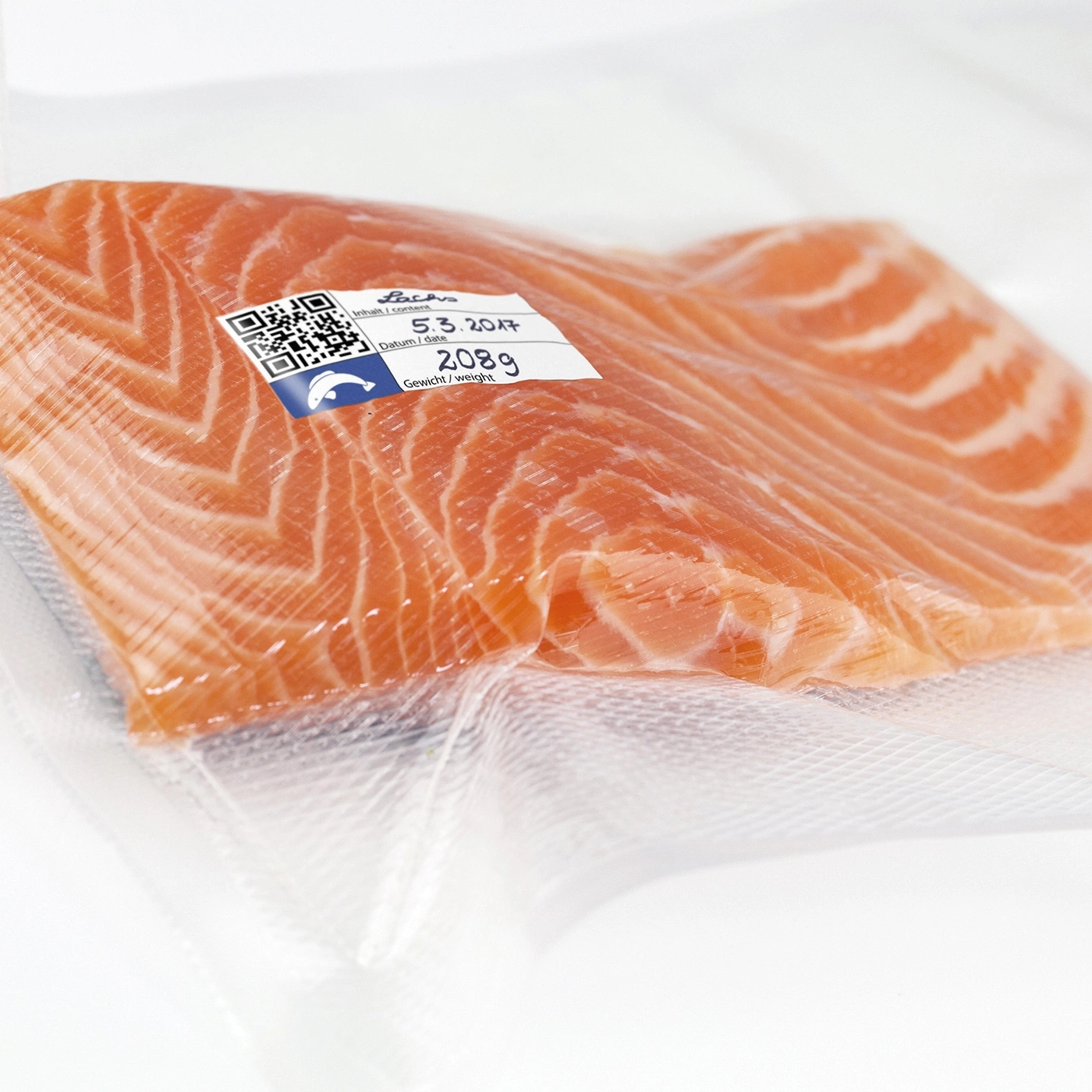 Salmon fillet packaged in foil, with label, date, and weight information.