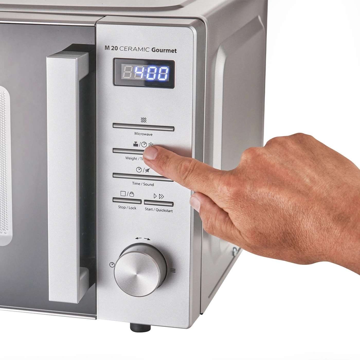 Microwave with control panel and hand pressing a button to set the time.